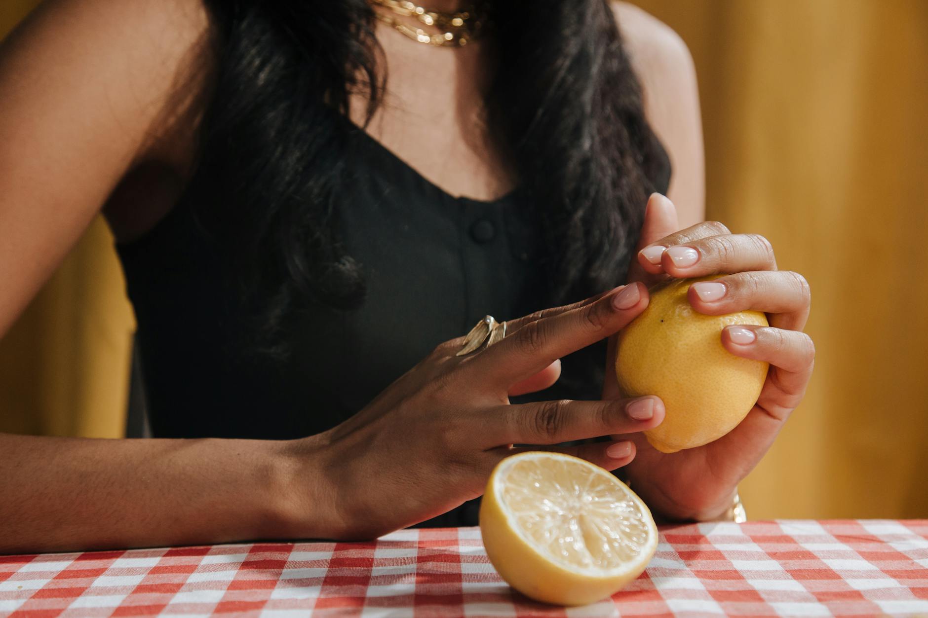 A hand holding a vibrator against a minimalistic backdrop