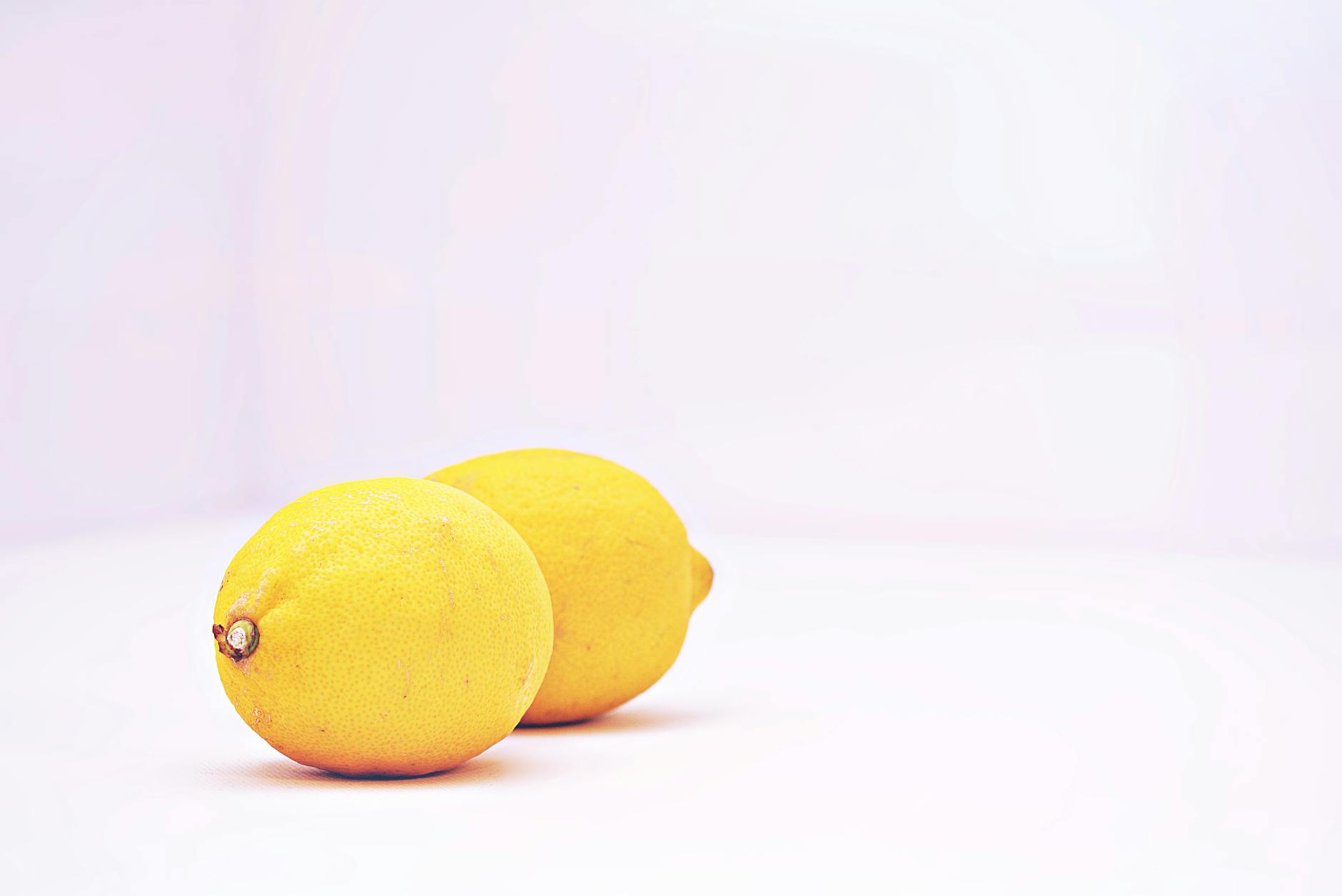 Two hands holding silicone vibrators against a pastel background, representing reclaiming sexual autonomy