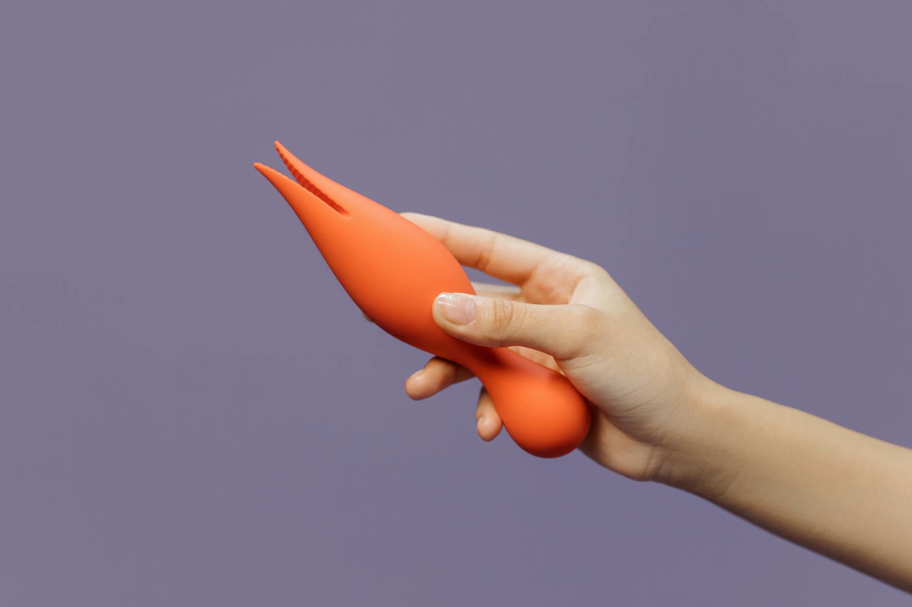 Intimate close-up of hands holding a sleek blue vibrator, showing partnership and shared exploration